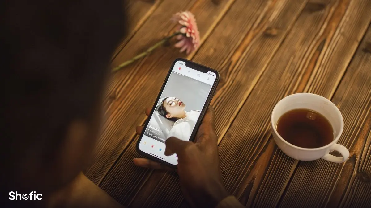 A hand holding a phone showing an Instagram profile