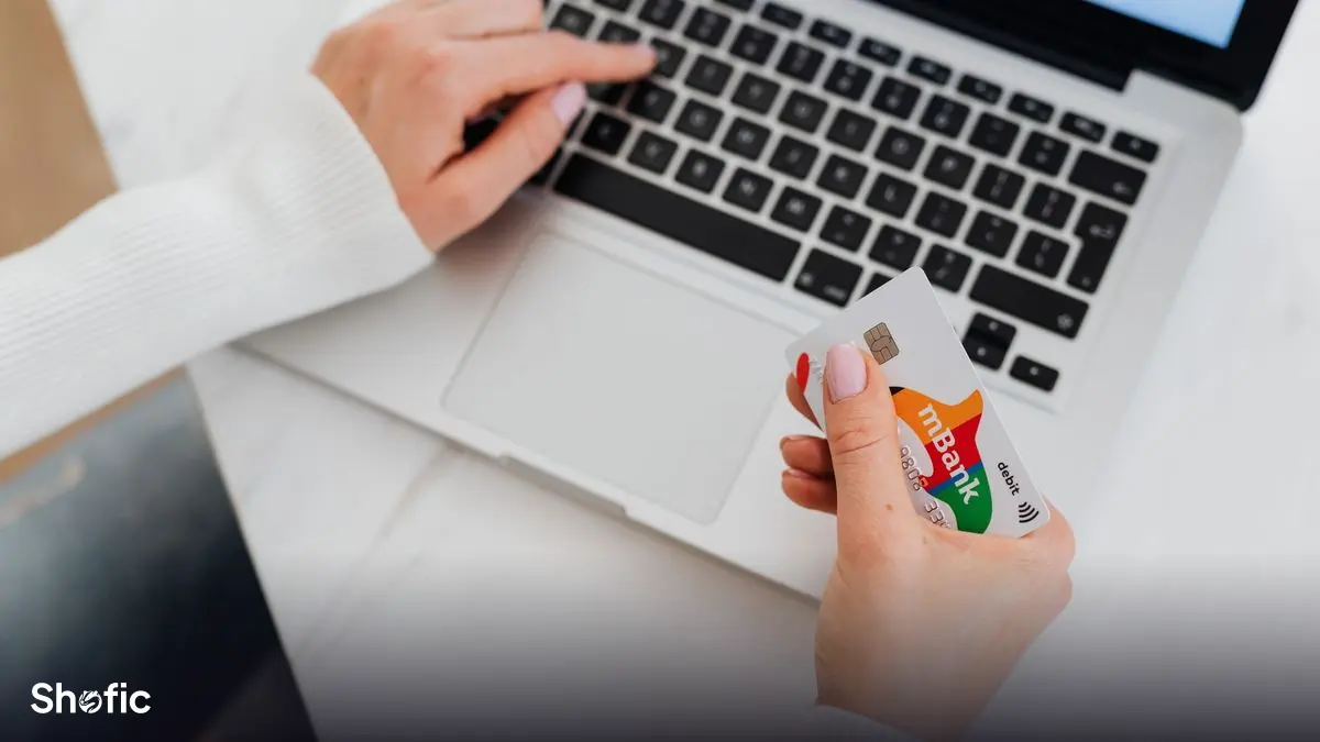Paying for an online order with a card on a laptop