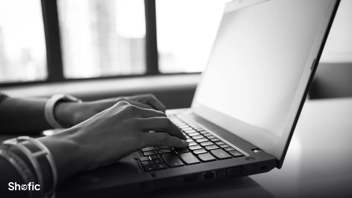Typing at a laptop on an office desk