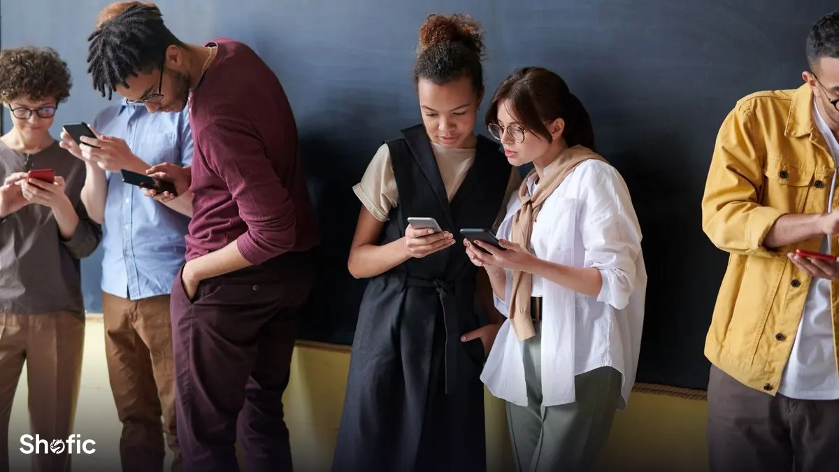 A group of people checking their phones together