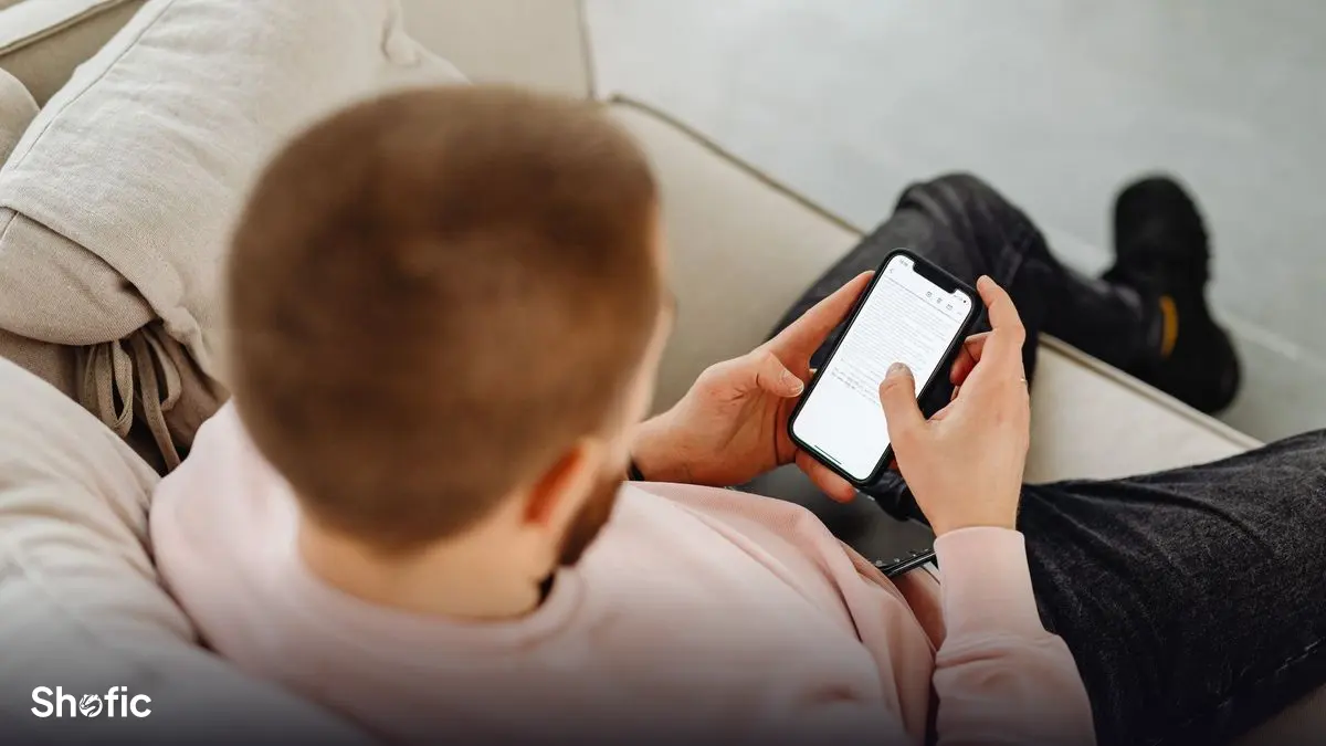 A young person scrolling TikTok on a sofa