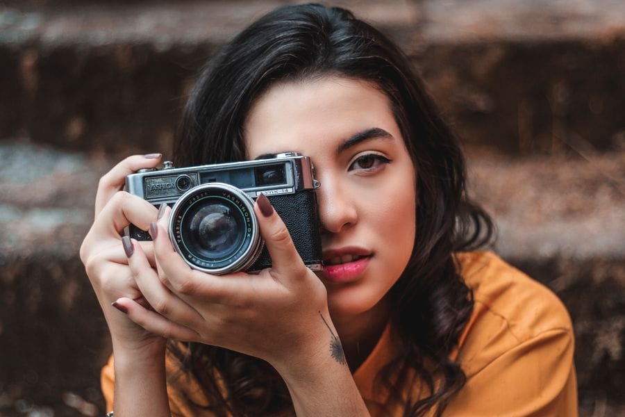 صانعة محتوى بقميص أصفر تصوّر بكاميرا