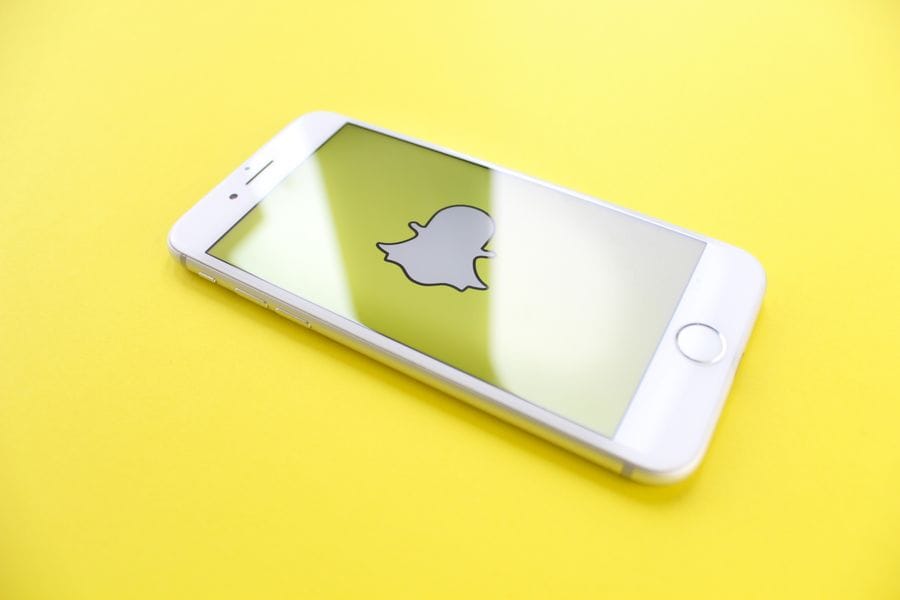 يد تحمل هاتفاً ذكياً يعرض تسجيل قصة على سناب شات